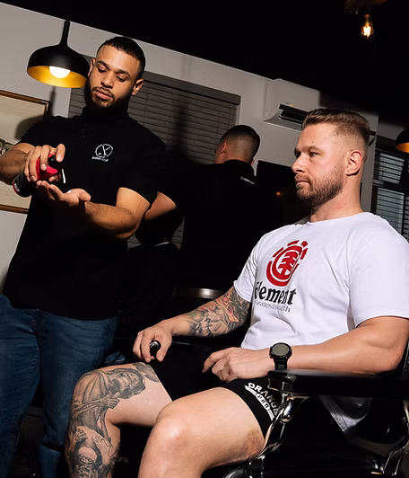 A barber preparing to start a cut, with the client waiting in the chair