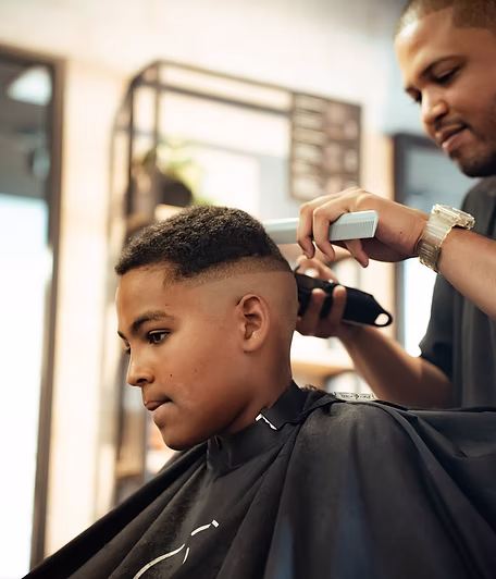 A young client having a fade clipped in at the back and sides