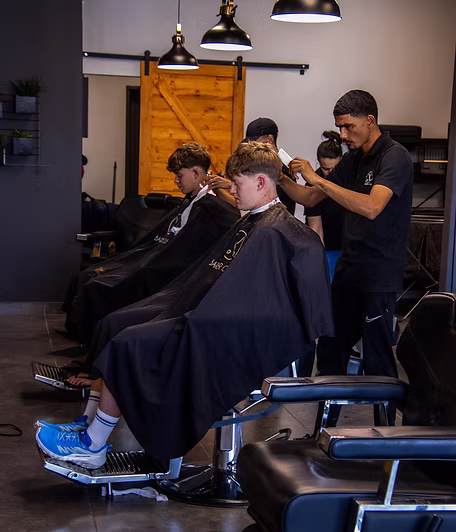 Two clients being cut side by side in adjacent chairs